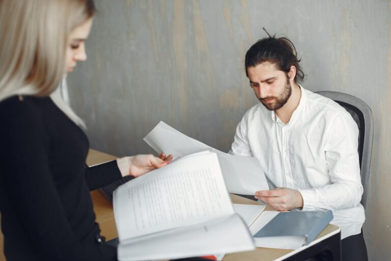 Two professionals reviewing important documents in a modern office setting