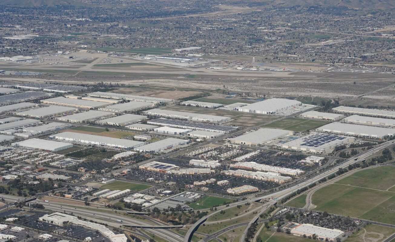Expansive aerial shot of industrial area near a major airport and urban landscape