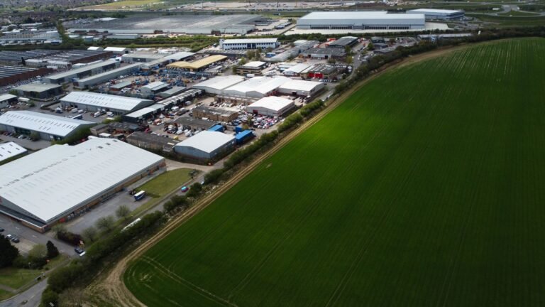 Aerial view showcasing the industrial park and lush green fields in Luton, England