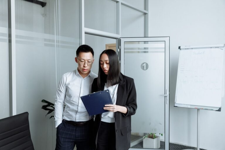 Two business professionals reviewing documents in a modern office setting
