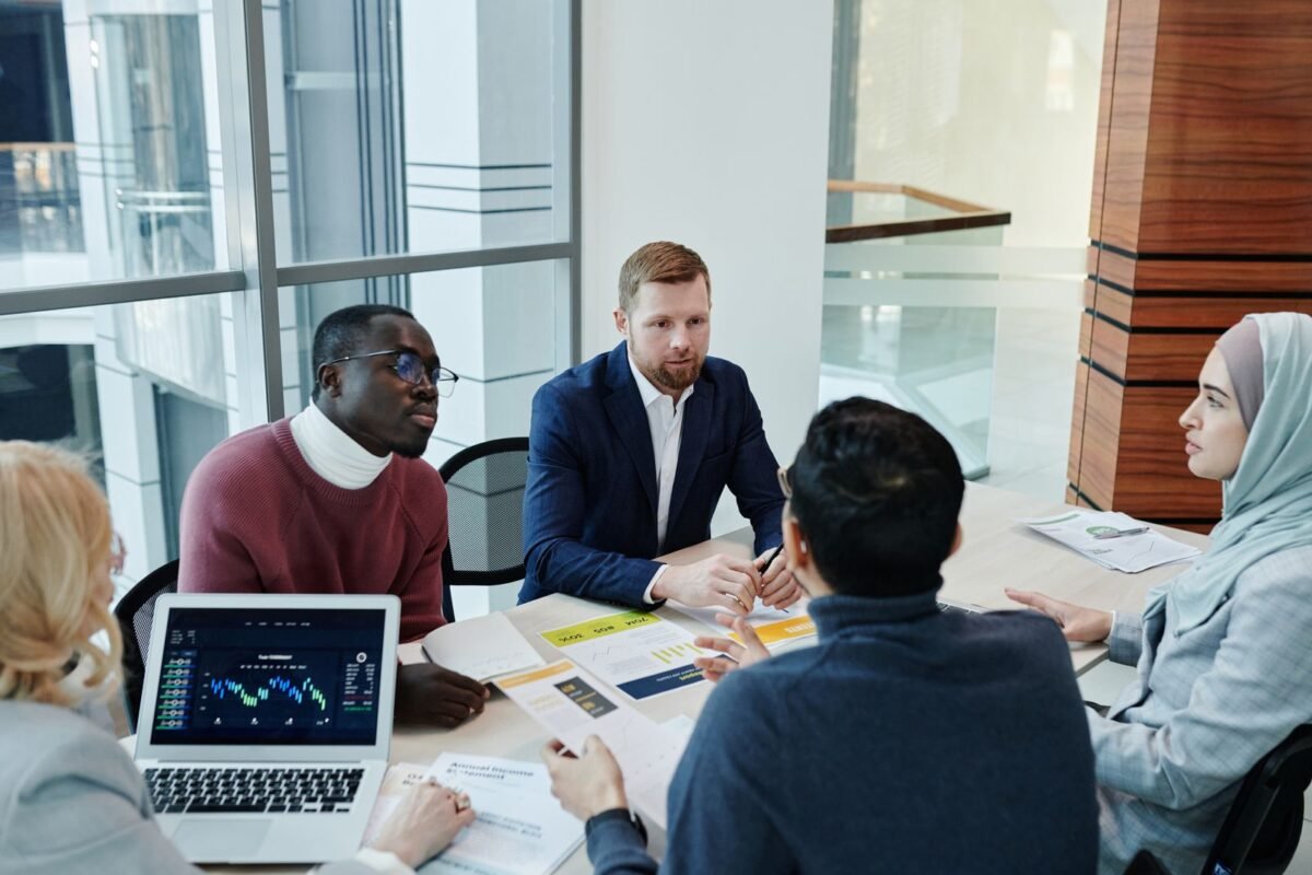 A diverse group of professionals engaged in an office meeting, discussing business strategies