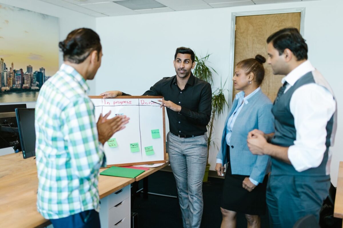 Diverse team discussing project progress with a board in a modern office