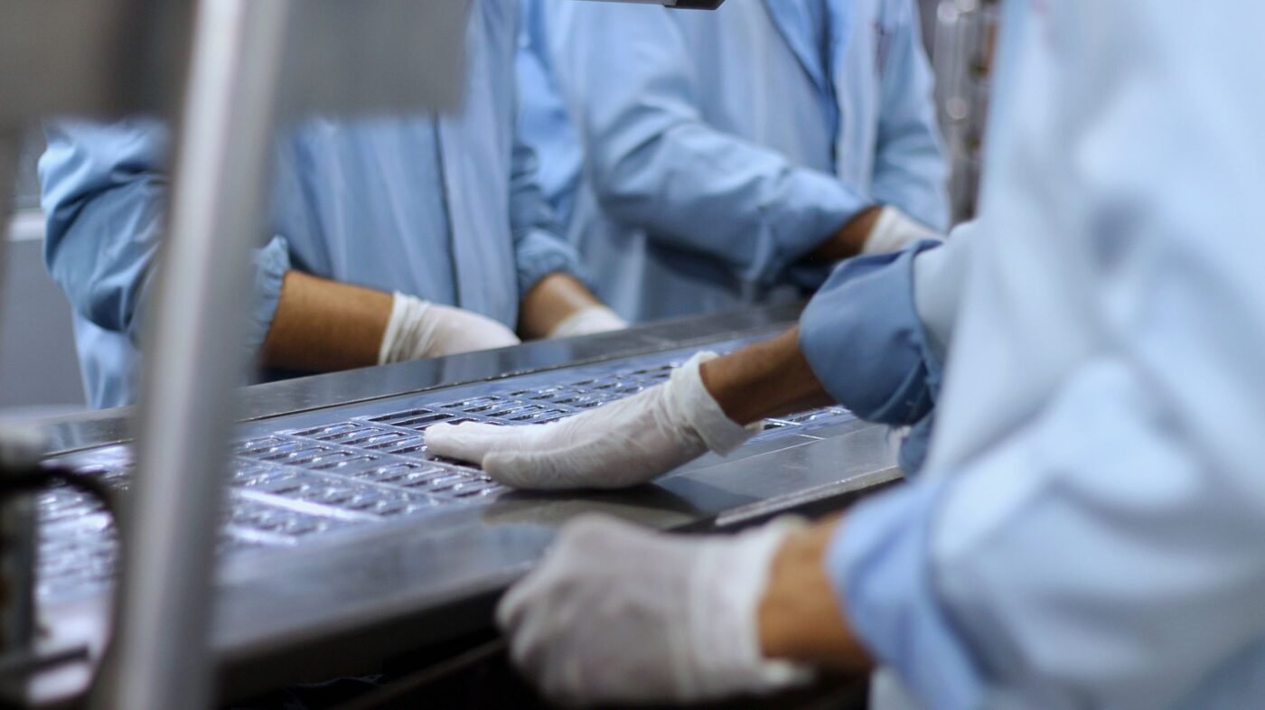 Workers packaging tablets in a pharmaceutical facility