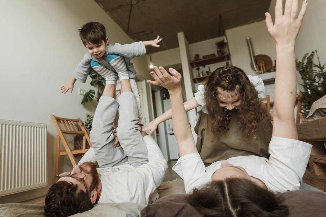 Happy family playing together indoors expressing love and joy in a cozy home setting