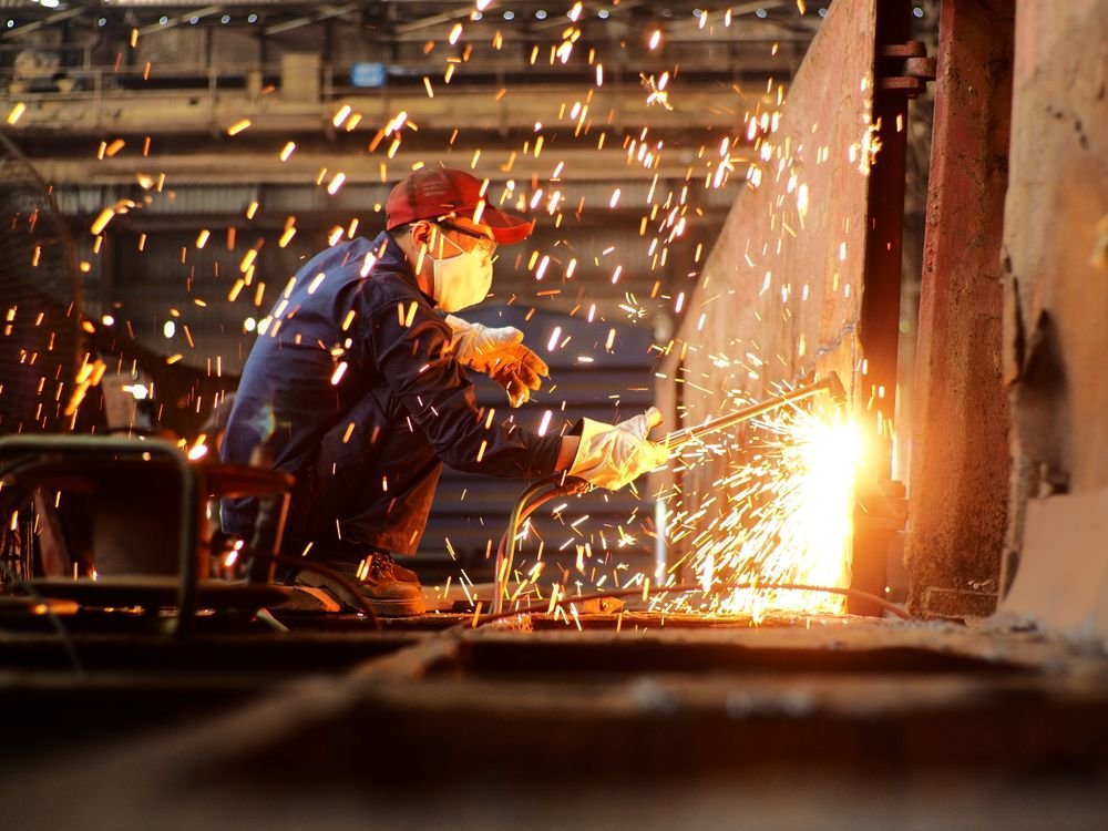Hỗ trợ đào tạo lao động, xây nhà ở công nhân: ưu đãi phi thuế cho FDI 1 Welder wearing safety gear working in a factory surrounded by sparks