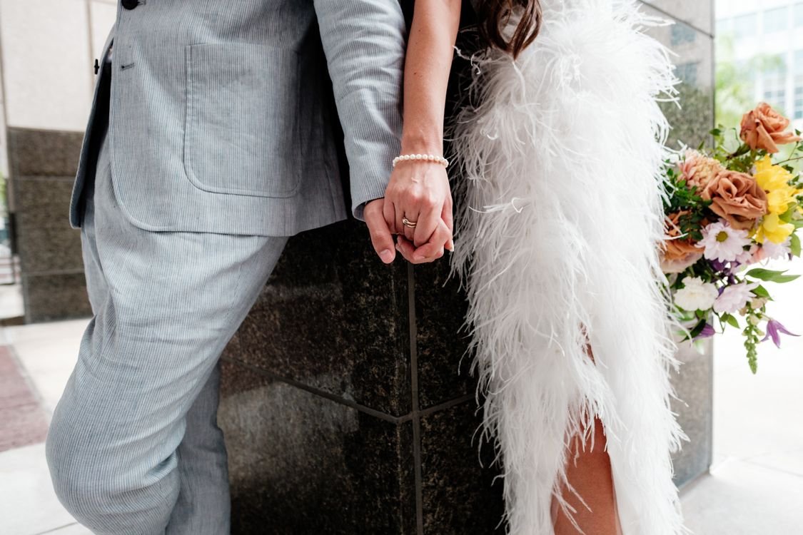 How Much Does a Spouse Get in Intestate Succession? 1 Stylish couple in feathered dress and suit holding hands on their wedding day
