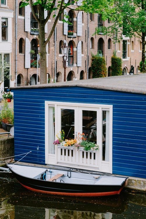 A small house on a canal with a boat in front