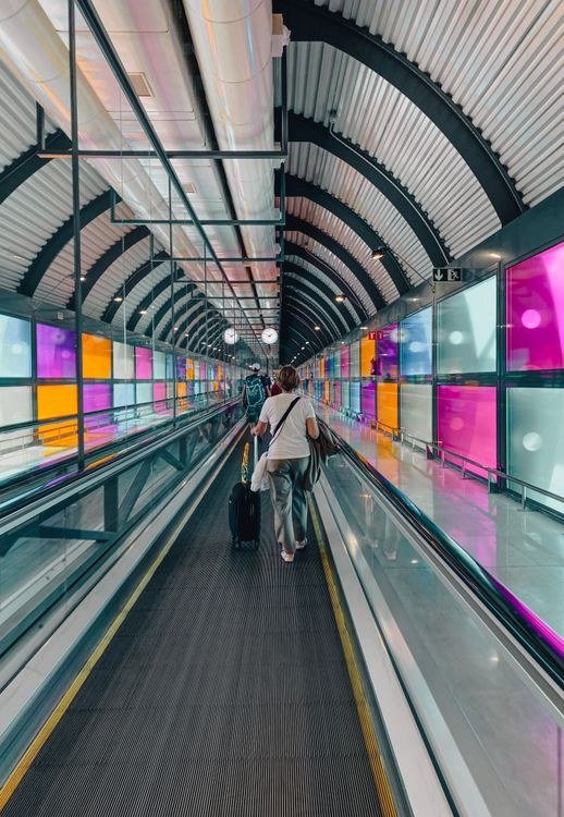 Woman with a Suitcase Standing on a Moving Walkway at Madrid Airport, Spain