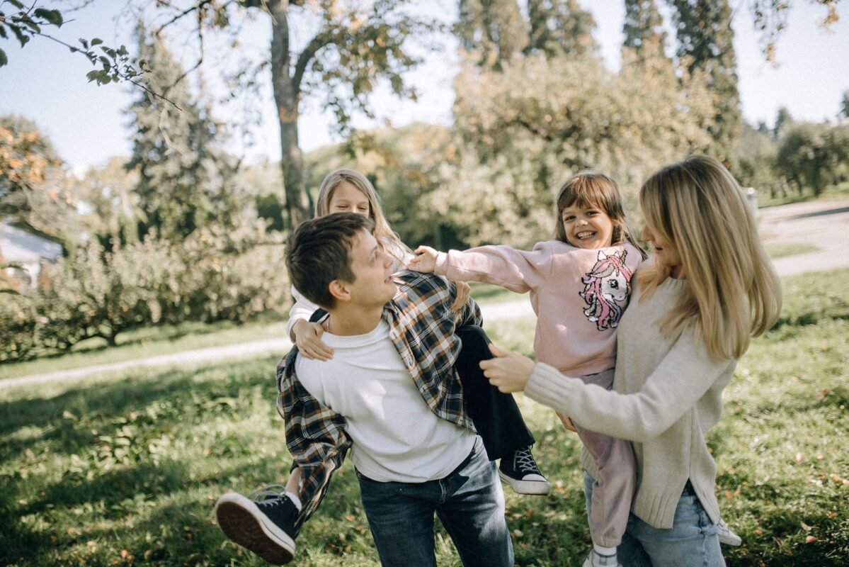 Temporary Residence Registration for Foreigners' Children 1 A joyful family spending quality time together in a green park on a sunny day.