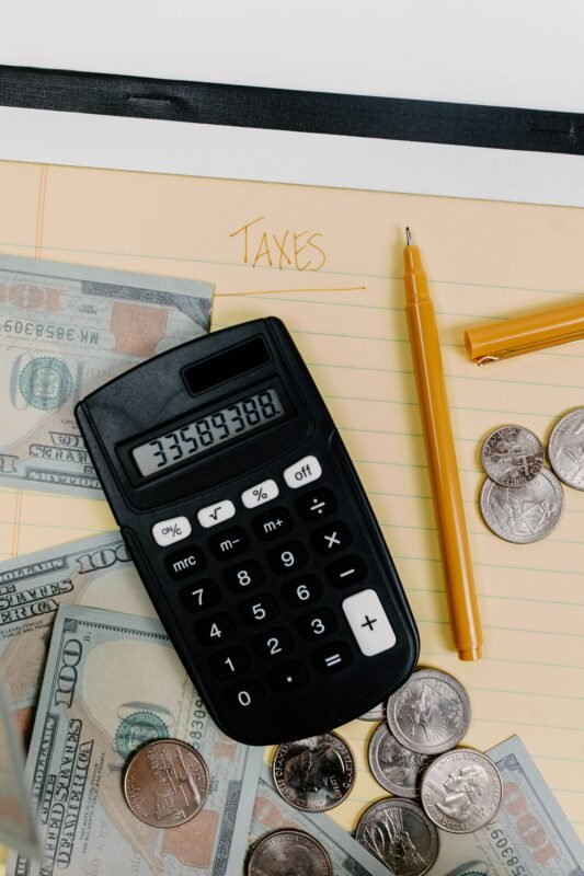 Can voluntary back-payment of tax before prosecution avoid criminal liability — calculator, cash and a notebook labeled Taxes