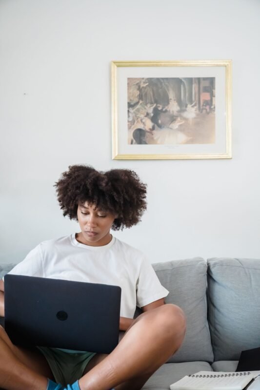 Woman with laptop on couch at home