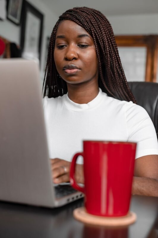 Woman using a laptop with coffee