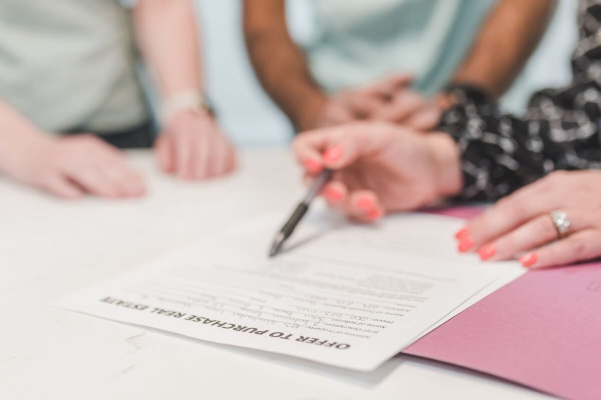 Person holding ballpen on white paper