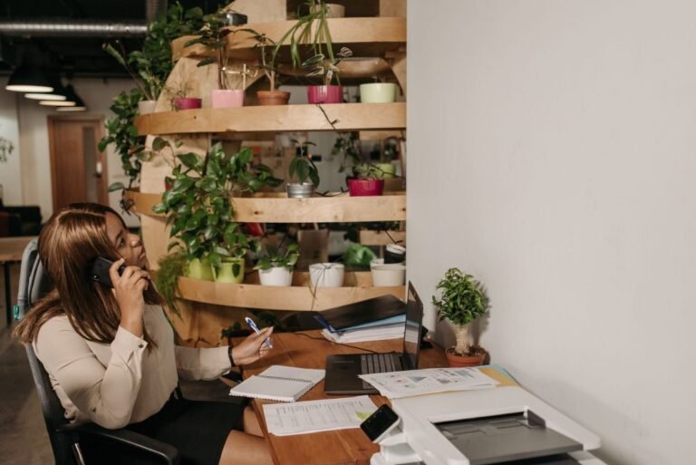 Góc làm việc xanh với cây cảnh, laptop và báo cáo trên bàn — minh họa báo cáo ESG, phát triển bền vững