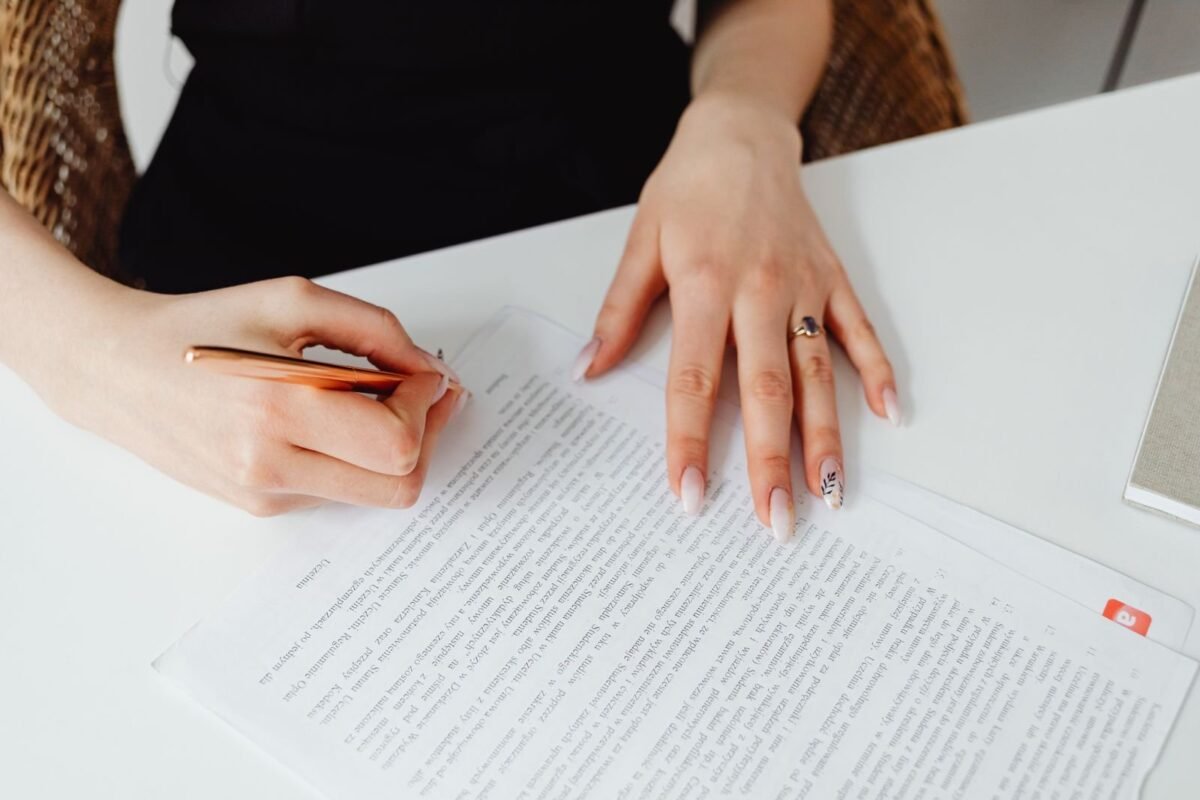 Sợ di sản kèm nợ: từ chối nhận thừa kế thế nào cho đúng luật? 1 A woman signing a document with a pen on a desk, emphasizing hands and writing