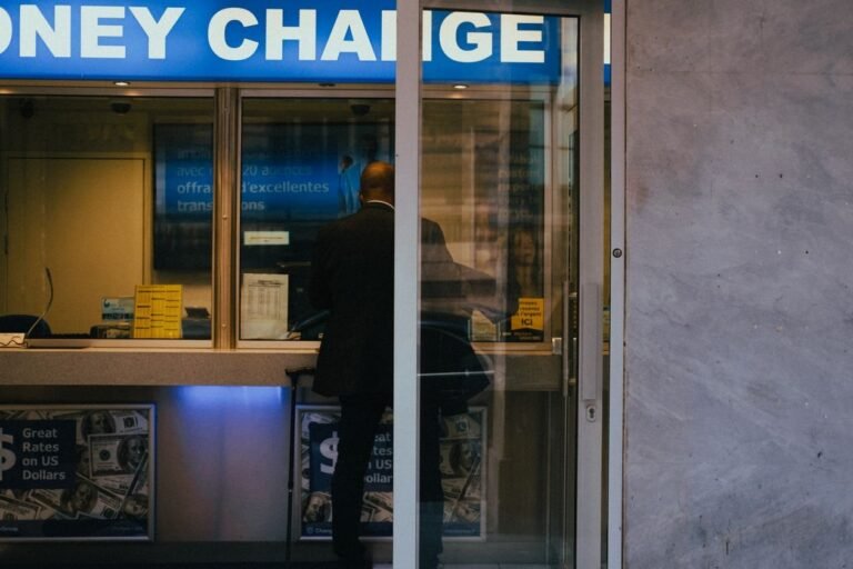 A man at a money exchange counter with US dollar posters — illustrating cross-border money transfer