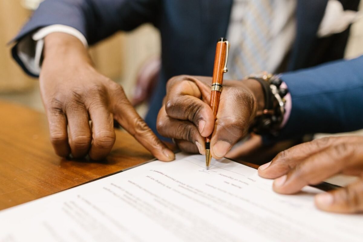 Two parties signing a contract on a desk
