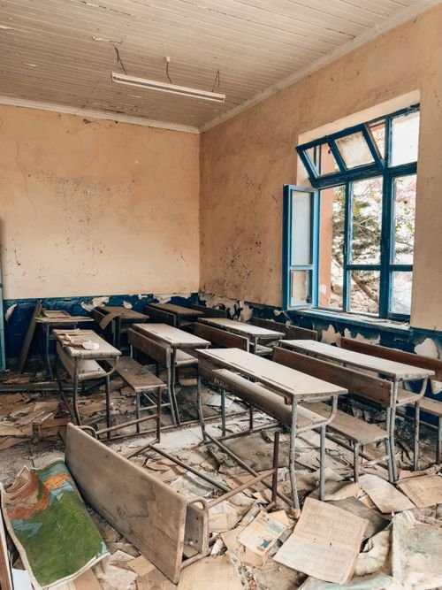 Abandoned classroom with broken desks — illustrating mid-term international school closure and refunds